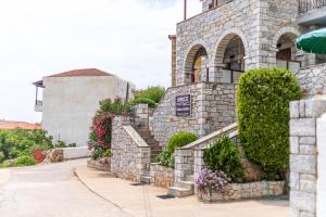 a stone building with flowers on the side of it at VRAHOS - o ΒΡΑΧΟΣ in Agios Nikolaos