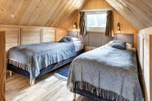 sypialnia z 2 łóżkami w drewnianym domku w obiekcie Bieszczadzka Łąka w mieście Kalnica