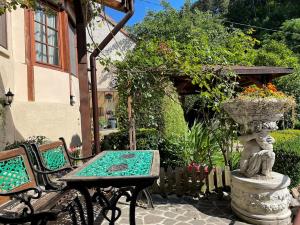 a table and bench in a garden with a fountain at Dream House Brasov in Braşov