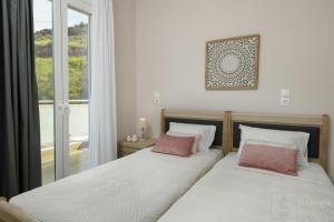 two beds sitting next to each other in a bedroom at Villa Eurycleia - AKTI homes in Pitsidia