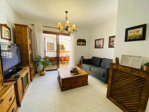 a living room with a couch and a tv at Mar Holiday Home in Los Cristianos