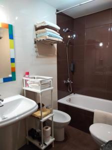 een badkamer met een wastafel, een toilet en een bad bij Solaina Parking gratuito in Viveiro