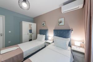 two beds in a bedroom with blue and white at Great Location Apartment in Varna City