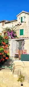 a building with a patio with benches and flowers at Apartment Alena with terrace and garden Center Jelsa in Jelsa