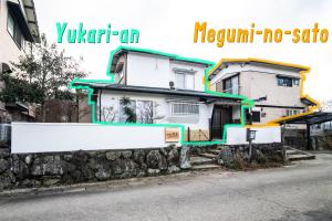 una casa blanca al lado de una calle en Yufuin Yukari-an Megumi no Sato, en Yufu