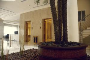 un vestíbulo con una palmera en un edificio en Rafa Homes - Al Falah, en Riad