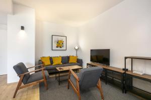 a living room with a couch and a table and yellow pillows at Marbella Real - 2 Bedroom Apartment in Marbella