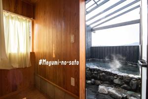 a hot tub in a room with a window at Yufuin Yukari-an Megumi no Sato in Yufu
