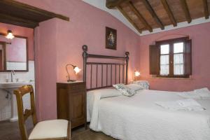 1 dormitorio con paredes rosas, 1 cama y lavamanos en Podere La Casetta - Casa di Campagna en Montaione