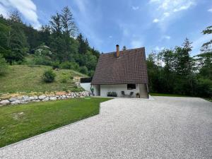 a house on a hill with a gravel driveway at Our Forest House in Tržič