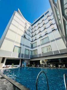 a hotel with a swimming pool in front of a building at Sahid Batam Center Hotel and Convention in Batam Center