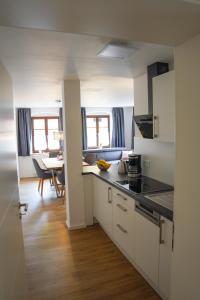 una cocina con armarios blancos y una mesa en una habitación en Hänsel und Gretel, en Dinkelsbühl