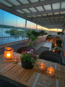 a table on a balcony with candles and flowers at Malminranta in Savonlinna