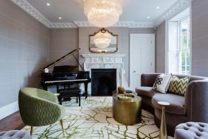 een woonkamer met een bank en een piano bij Veeve - Pears and Graces in Londen