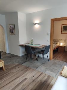 a dining room with a table and chairs and a bedroom at Ferienwohnung Mühlburger in Lienz