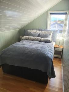 a bedroom with a large bed with a window at Idyllisk sjøhus på Naurstad in Bodø
