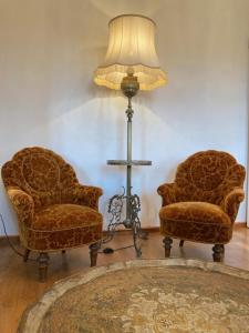 two chairs and a floor lamp in a living room at Napoleonzimmer / Studio in Maring-Noviand