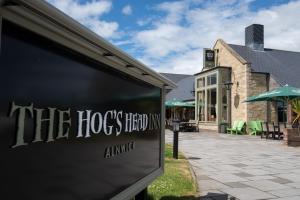 a building with a sign that reads the hos head inn at The Hog's Head Inn - The Inn Collection Group in Alnwick