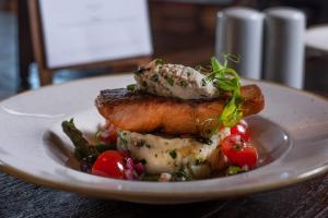 a plate of food with meat and vegetables on a table at The Hog's Head Inn - The Inn Collection Group in Alnwick +33 photos