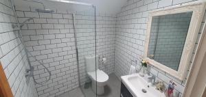 ein weiß gefliestes Bad mit einem WC und einem Waschbecken in der Unterkunft Gite Coquille Saint Jacques in Nanteuil-en-Vallée