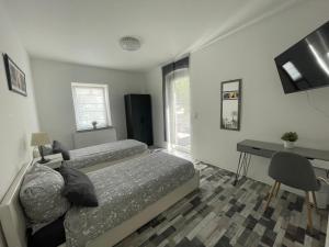 1 dormitorio con 2 camas, escritorio y mesa en Ferienwohnung Herkulesblick, en Kassel