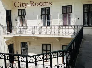 a building with balconies and a sign that reads city rooms at City Rooms in Budapest