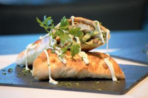 two pizzas with greens on top on a plate at Hotel Das Zeit in Lenzing