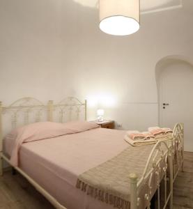 1 dormitorio con 1 cama blanca con sábanas rosas en CasaCalò, en Gallipoli