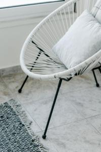 a white chair with a pillow on a tile floor at Zen Sea in Alexandroupoli
