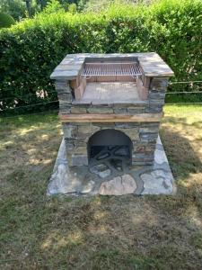a stone fireplace with a bench in a yard at Villa Tirolese in Due Cossani