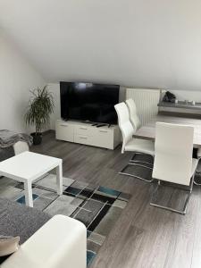 uma sala de estar com mobiliário branco e uma televisão de ecrã plano em Appartement GL24 em Sankt Margarethen bei Knittelfeld