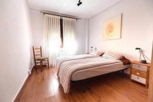 - une chambre avec un lit, une chaise et une fenêtre dans l'établissement El apartamentín de Lastres, à Lastres
