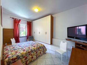 a bedroom with a bed and a flat screen tv at Appartamento La Costarella in Marciana