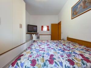 a bedroom with a bed with a colorful quilt on it at Appartamento La Costarella in Marciana