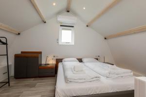 1 dormitorio con 2 camas en una habitación pequeña en Welcome in - Vakantiewoning met sauna en zonnig terras, en Biggekerke