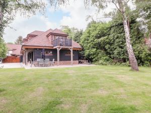 ein Haus mit einer Terrasse und einem Hof in der Unterkunft The Barn at Mulberry Lodge in Maidstone