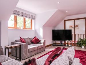 a living room with two couches and a flat screen tv at The Barn at Mulberry Lodge in Maidstone