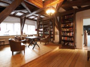 eine Bibliothek mit einem Tisch, Stühlen und Bücherregalen in der Unterkunft Schloss Hotel Burgbrohl in Burgbrohl