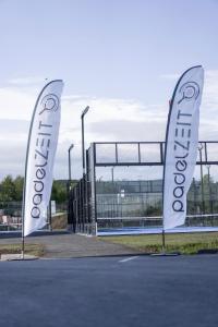 two white flags in front of a gate at Hotel Das Zeit in Lenzing