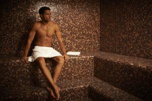 a man sitting on a wall in a brick room at Schloss Hotel Burgbrohl in Burgbrohl