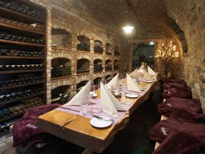 a long table in a wine cellar with wine bottles at Schloss Hotel Burgbrohl in Burgbrohl