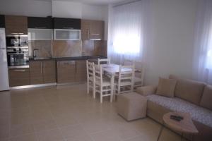 cocina y sala de estar con sofá y mesa en Everest Apartments Shengjin, en Shëngjin