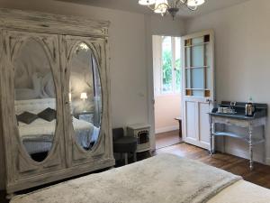 a bedroom with a large mirror and a bed at Chalet des Palmiers in Bagnères-de-Bigorre