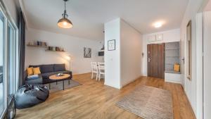 ein Wohnzimmer mit einem Sofa und einem Tisch in der Unterkunft Apartamenty Sun & Snow Baltic Park II in Pogorzelica