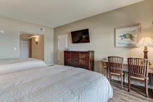 a bedroom with a bed and a desk with two chairs at 328 Sandcastle condo in Fernandina Beach