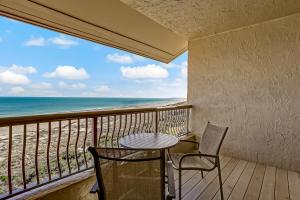 a balcony with a table and chairs and the ocean at 328 Sandcastle condo in Fernandina Beach