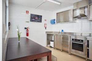 a kitchen with stainless steel appliances and a black counter top at Suites & Hostel Cidade Aveiro in Aveiro