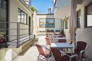 eine Reihe von Tischen und Stühlen auf einem Balkon in der Unterkunft Suites & Hostel Cidade Aveiro in Aveiro