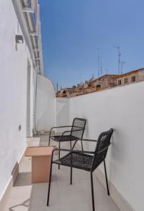 a row of chairs and a table on a balcony at limehome Madrid Calle de Fomento - Digital Access in Madrid