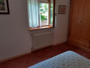 a bedroom with a window and a tiled floor at La porta verde di Trento in Romagnano